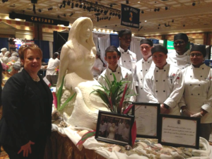 Mercer County Freeholder Ann Cannon with culinary arts students of Mercer County Technical Schools at the 2014 NJAC County Vocational-Technical School Cook-Off Challenge.  Serena, the mermaid, was created of lard by the students.