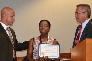 Middlesex County Freeholder Director Ron Rios presents a certificate and the 2015 NJAC Foundation Scholarship check from Investors Bank to Shakyran Gaskin, who plans to study psychology at Kean University.